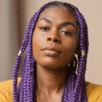 Person wears purple braided hair and yellow shirt.