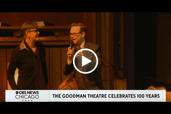 Audience member and Dennis Watkins with a microphone conversating beside the stage.